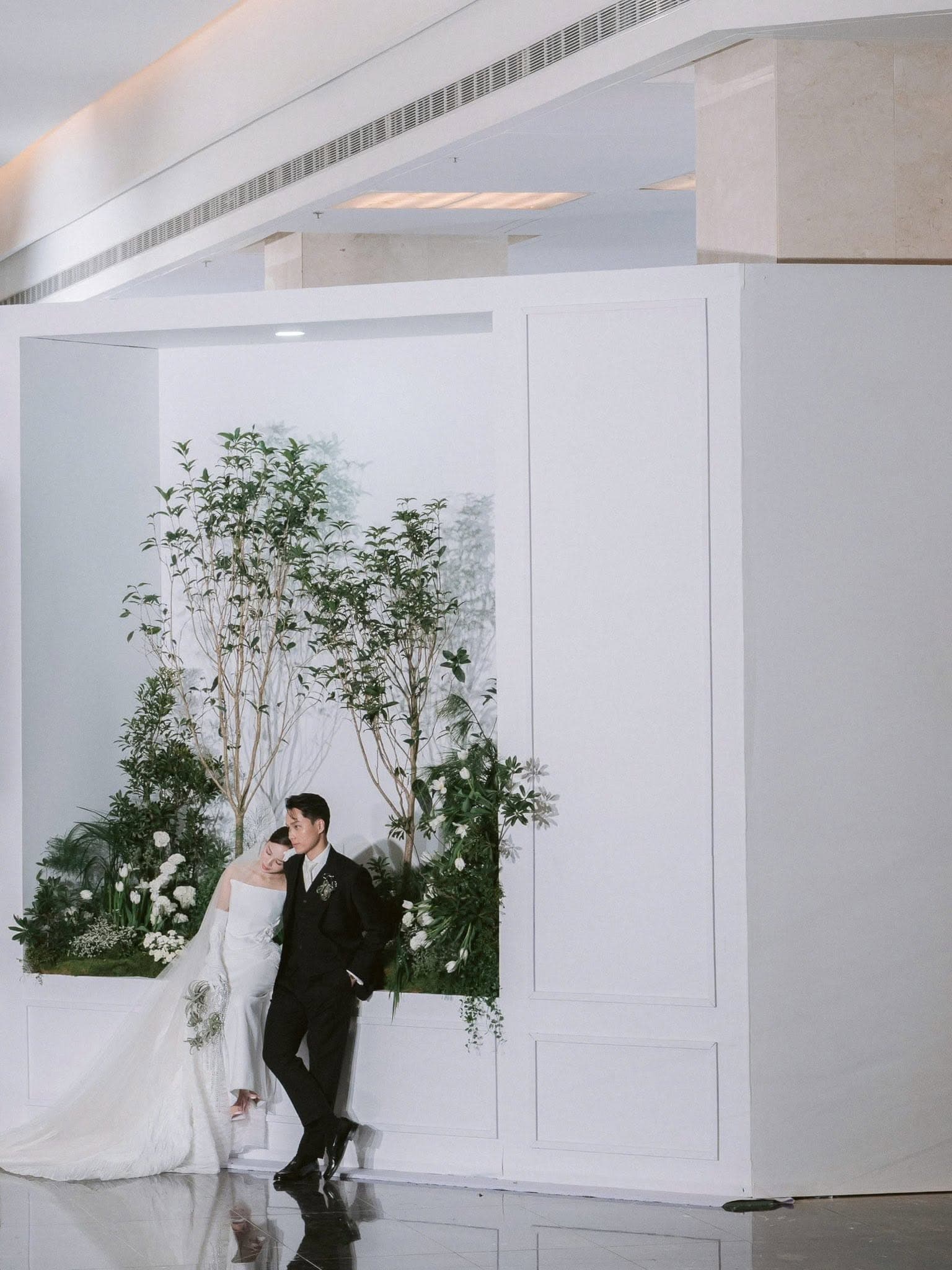White florals arranged against dark velvet drapery